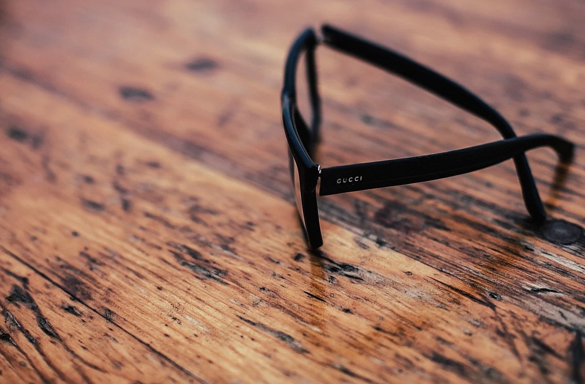 mesa de madera, gafas de sol negras